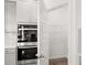 Kitchen featuring a pantry, stainless steel double oven, white countertops, and gray cabinetry at 1861 Lacebark Elm Way, Lawrenceville, GA 30045