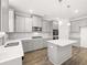 Kitchen featuring white quartz countertops, gray cabinetry, island, and stainless appliances at 1861 Lacebark Elm Way, Lawrenceville, GA 30045