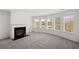 Bright living room featuring a fireplace, gray carpet, and large windows with natural light at 1861 Lacebark Elm Way, Lawrenceville, GA 30045