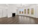 Spacious living room with wood floors, a fireplace, and a curved wall of bright windows at 1861 Lacebark Elm Way, Lawrenceville, GA 30045