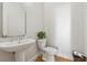 Bright powder room with pedestal sink, oval mirror, and hardwood flooring at 551 Straton Chase Se, Marietta, GA 30067