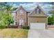 Charming two-story home featuring a brick facade, well-manicured lawn, and attached two-car garage at 114 Farm Valley Dr, Canton, GA 30115