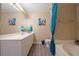 Bright bathroom featuring white vanity, large mirror, soaking tub with blue accents at 5099 Leeshire Trce, Tucker, GA 30084