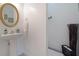 Bathroom featuring a pedestal sink, a round mirror, and neutral decor at 5099 Leeshire Trce, Tucker, GA 30084