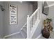 Carpeted staircase featuring white banister and a decorative wall art at 5099 Leeshire Trce, Tucker, GA 30084