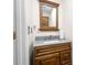 Powder room with a granite countertop, a wood cabinet, and a decorative mirror at 1208 Lauren Nw Ct, Acworth, GA 30101