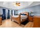 Main bedroom with a tray ceiling, a ceiling fan, and a large window at 1208 Lauren Nw Ct, Acworth, GA 30101
