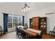 Elegant dining room features ample windows, sleek lighting, wood floors, and large wooden cabinet with decorative dishware at 1605 Dr Bramblett Rd, Cumming, GA 30028