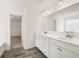 Bright bathroom with double sink vanity, white cabinetry, tile flooring, and a doorway to the walk-in closet at 1838 Lacebark Elm Way, Lawrenceville, GA 30045