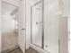 Bright bathroom featuring a glass-enclosed shower and tile flooring, conveniently located near a bedroom at 1838 Lacebark Elm Way, Lawrenceville, GA 30045