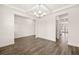 Spacious room featuring hardwood floors and neutral walls, adjacent to other living spaces at 1838 Lacebark Elm Way, Lawrenceville, GA 30045