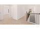 Hallway with neutral carpet leading to bedrooms, with railing on the stairs at 1838 Lacebark Elm Way, Lawrenceville, GA 30045