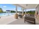 Covered patio overlooking the pool with comfortable seating and stone columns at 1838 Lacebark Elm Way, Lawrenceville, GA 30045