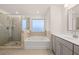 Modern bathroom featuring a glass shower, separate tub, and a vanity with granite countertop at 1828 Lacebark Elm Way, Lawrenceville, GA 30045