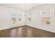 Bright dining room with hardwood floors, modern chandelier, and access to the backyard through French doors at 1828 Lacebark Elm Way, Lawrenceville, GA 30045