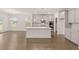 Open kitchen boasts granite countertops, an island with a sink, stainless steel appliances, and hardwood floors at 1828 Lacebark Elm Way, Lawrenceville, GA 30045