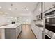 Spacious kitchen featuring stainless steel appliances, a granite island, hardwood floors, and an open layout at 1828 Lacebark Elm Way, Lawrenceville, GA 30045
