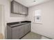 Functional laundry room featuring upper cabinets, a window, and ample countertop space at 1828 Lacebark Elm Way, Lawrenceville, GA 30045