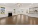 Bright and spacious living room with hardwood floors, a fireplace, and an adjacent kitchen at 1828 Lacebark Elm Way, Lawrenceville, GA 30045