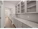 Convenient butler's pantry features glass-front cabinets, granite counters, and ample storage space at 1828 Lacebark Elm Way, Lawrenceville, GA 30045