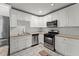Updated kitchen boasts white cabinetry, stainless steel appliances, granite counters and gray wood-look floors at 2790 Collier Nw Dr, Atlanta, GA 30318