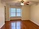 A comfortable bedroom featuring a ceiling fan, natural light from its windows, and hardwood floors at 3015 Camden Way, Alpharetta, GA 30005
