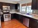 Bright kitchen with stainless steel appliances, dark wood cabinets, and laminate countertops at 3015 Camden Way, Alpharetta, GA 30005
