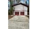 Two car garage featuring red doors with glass inserts and a concrete driveway at 4829 Woodhurst Way, Stone Mountain, GA 30088