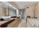 Luxurious bathroom featuring dual sinks, a large mirror, a jetted tub, and a glass shower at 2590 Runic Way, Johns Creek, GA 30022
