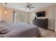 Bedroom with a gray quilted bedspread, ceiling fan, and a view of the bathroom at 2590 Runic Way, Johns Creek, GA 30022