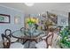 Bright dining area with glass table and chairs, and open view of the living room with modern staircase at 2590 Runic Way, Johns Creek, GA 30022