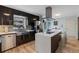 Modern kitchen features stainless steel appliances, dark cabinetry, and a large island with quartz countertops at 2590 Runic Way, Johns Creek, GA 30022