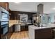 Modern kitchen features stainless steel appliances, dark cabinetry, and a large island with quartz countertops at 2590 Runic Way, Johns Creek, GA 30022