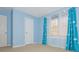 Bright bedroom with light blue walls, neutral carpet, one window with blinds, a closet, and cloud patterned curtains at 1231 Wildcliff Cir, Atlanta, GA 30329