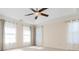 Bright bedroom featuring a ceiling fan, neutral walls, a tray ceiling, and ample natural light from the many windows at 1231 Wildcliff Cir, Atlanta, GA 30329