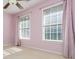 This bedroom has neutral carpet, soft pink walls, two sunny windows, and attractive pink curtains at 1231 Wildcliff Cir, Atlanta, GA 30329