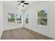 Sun-drenched bedroom with hardwood floors, a ceiling fan, and three windows overlooking the backyard at 240 Mount Zion Rd, Hapeville, GA 30354