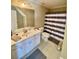 Bathroom with white vanity and gray striped shower curtain at 3817 Bay Orchard Ln, Loganville, GA 30052