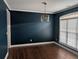 Dining room featuring dark walls, hardwood floors, and a modern light fixture at 510 Pittman Mill Ct, Loganville, GA 30052