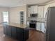 Elegant kitchen featuring granite counters, white cabinets, stainless appliances, and a spacious island at 510 Pittman Mill Ct, Loganville, GA 30052