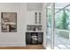 Stylish bar area with black and white cabinets, geometric backsplash, beverage cooler, and access to an outdoor deck at 1464 Ezra Church Nw Dr, Atlanta, GA 30314