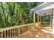Wooden deck surrounded by lush greenery with ceiling fan, offering a serene outdoor living space at 1464 Ezra Church Nw Dr, Atlanta, GA 30314
