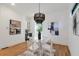 Contemporary dining area featuring a round glass table, white chairs, and sleek black and white accents at 1464 Ezra Church Nw Dr, Atlanta, GA 30314