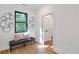 This entryway features a bench, hardwood floors, and a modern window with ring art at 1464 Ezra Church Nw Dr, Atlanta, GA 30314