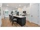 Bright kitchen featuring a black island, white cabinets, modern lighting and stainless steel appliances at 1464 Ezra Church Nw Dr, Atlanta, GA 30314