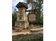 Stone monument at the entrance to Primrose Creek by Fischer Homes with landscaping at 1530 Avalon Creek Rd, Sugar Hill, GA 30518