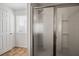 Bathroom with clear glass shower and white door with bronze fixtures at 1530 Avalon Creek Rd, Sugar Hill, GA 30518