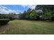 Large grassy backyard surrounded by trees, offering privacy and a serene outdoor space at 2604 Harman Park Cir, Duluth, GA 30097