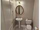 Charming half bath with a pedestal sink, decorative mirror, and classic fixtures at 2604 Harman Park Cir, Duluth, GA 30097