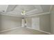 Spacious bedroom with a tray ceiling, ceiling fan, and double doors at 2604 Harman Park Cir, Duluth, GA 30097
